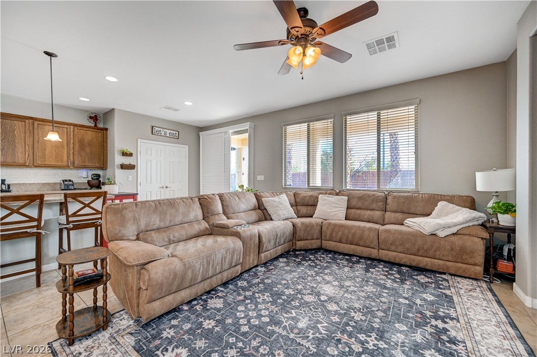 Tiled flooring and large windows enhance this welcoming living space adjacent to the kitchen.