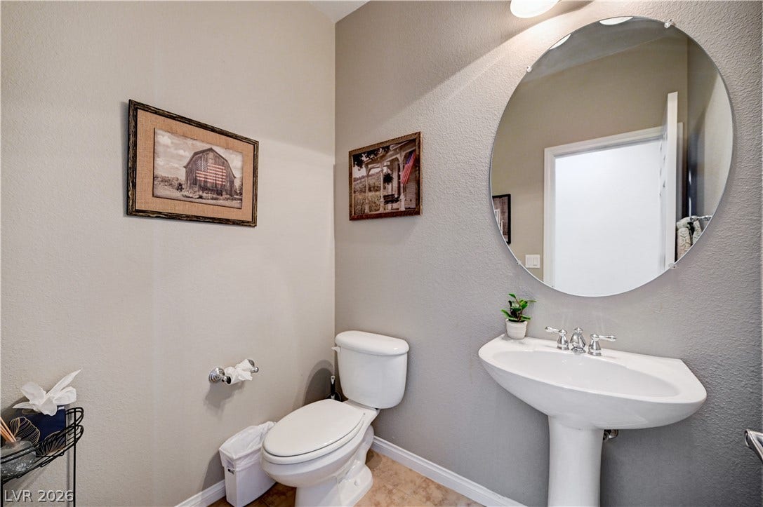 A classic pedestal sink paired with neutral walls completes this functional half bath.