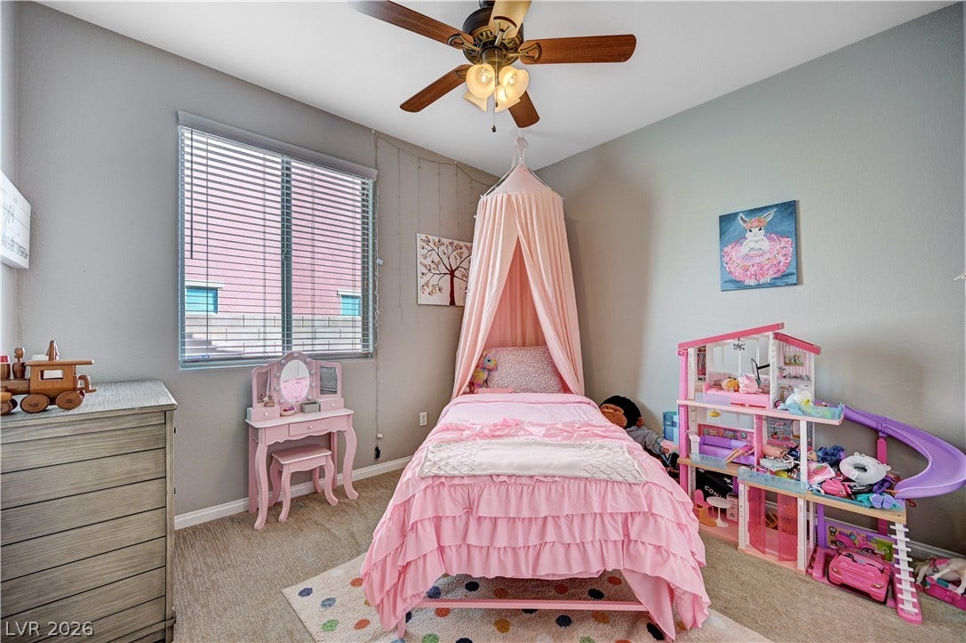 Natural light streams through a wide window onto neutral carpeting and soft-toned walls.