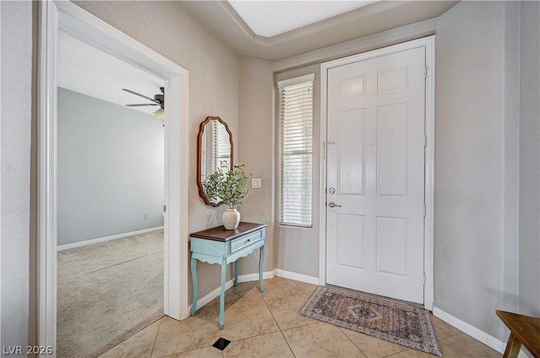 An inviting entryway features durable tile flooring and a tray ceiling detailing the foyer.
