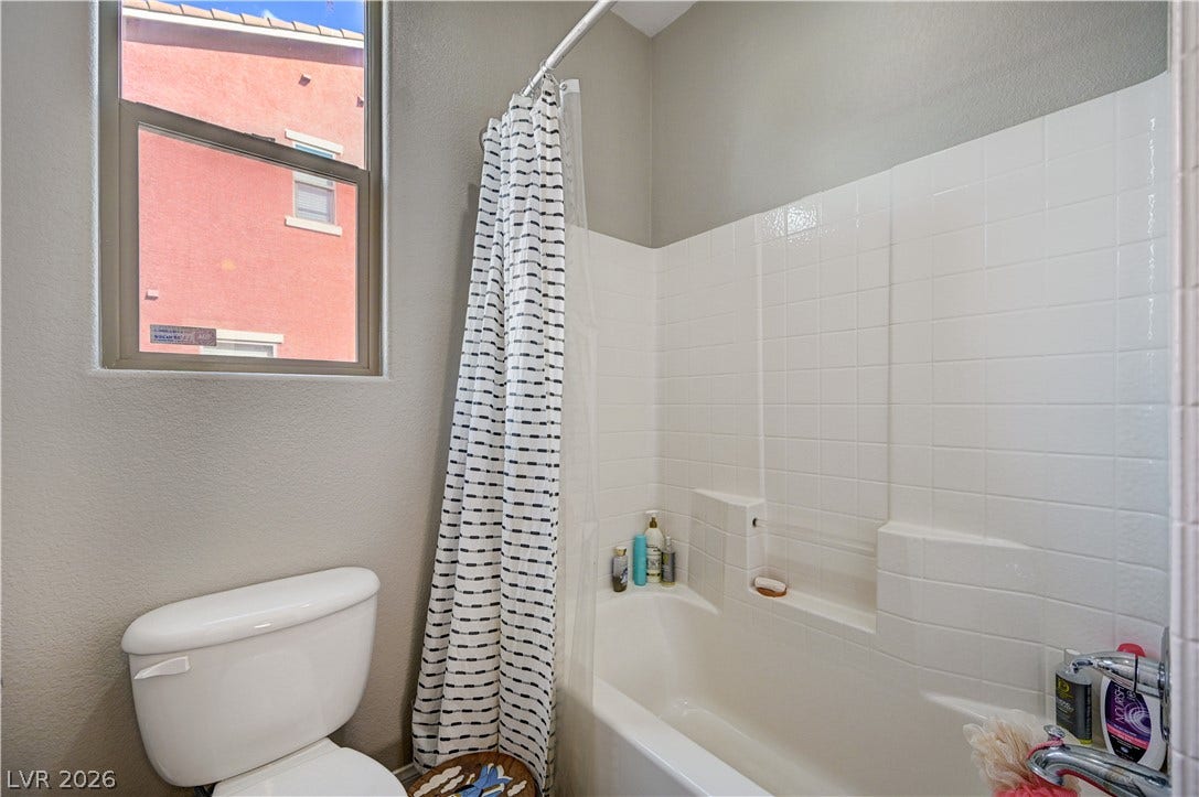 A classic bathtub and tile surround complement the neutral tones in this bathroom.