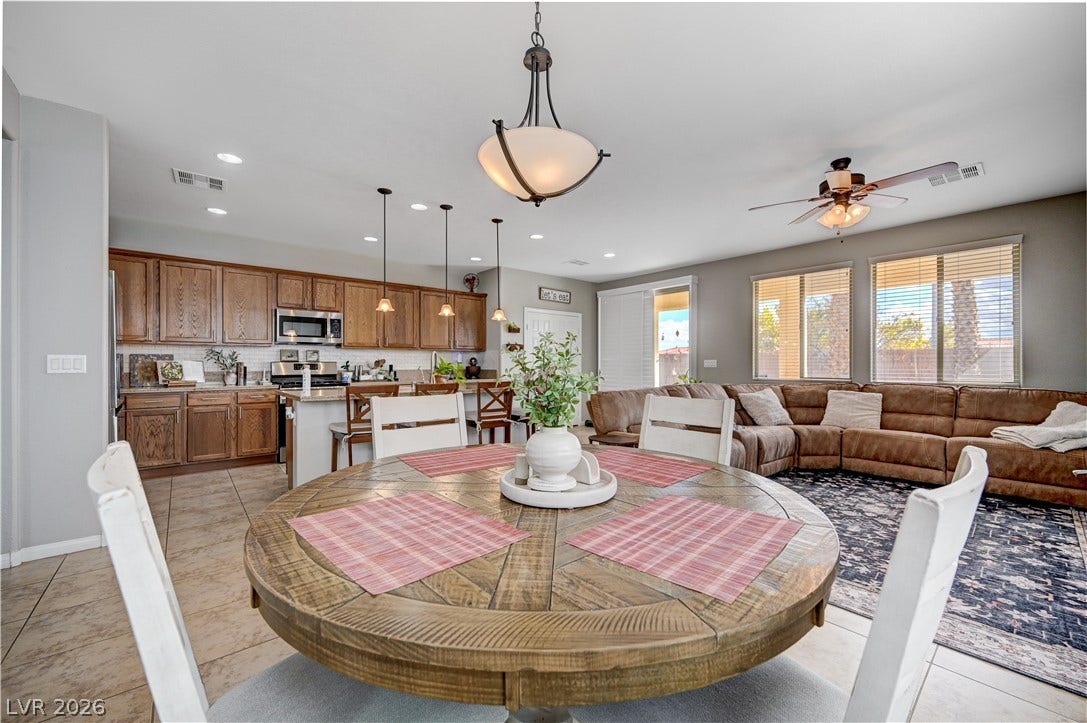 An open floor plan connects the kitchen, dining space, and living area under recessed lighting.