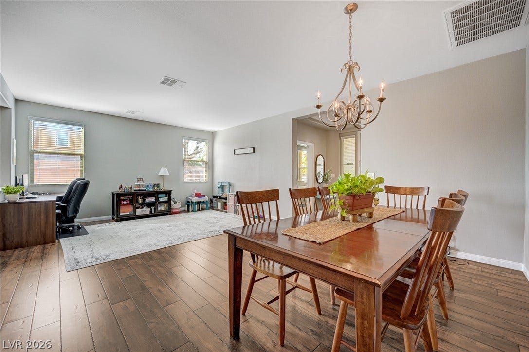 Gleaming hardwood floors and a classic chandelier define this open-concept dining area.