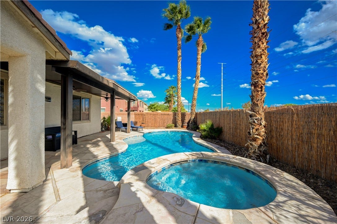 A private backyard oasis features a freeform swimming pool and an integrated spa.