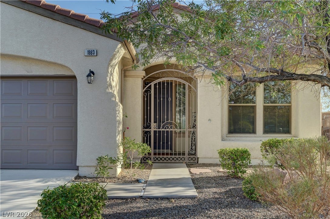 A secure gated entry and neat desert landscaping create inviting curb appeal.