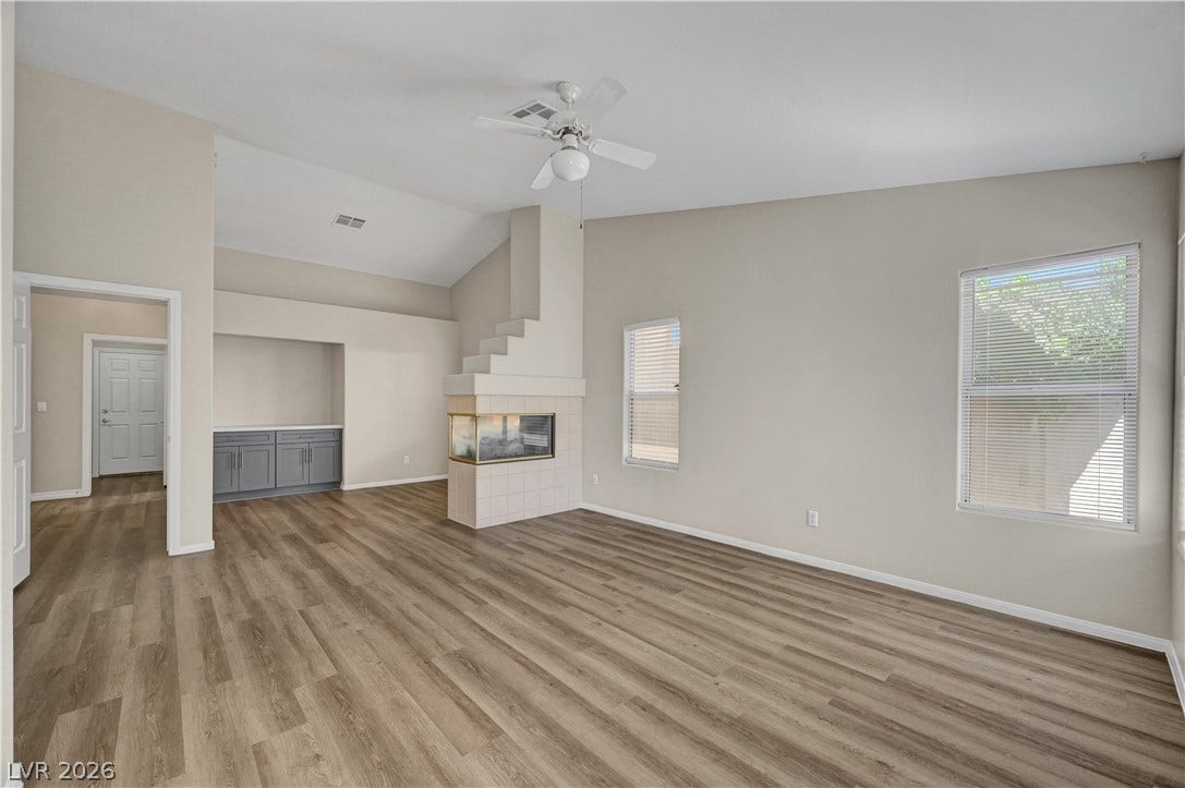 A unique three-sided fireplace anchors this airy living room with high vaulted ceilings.