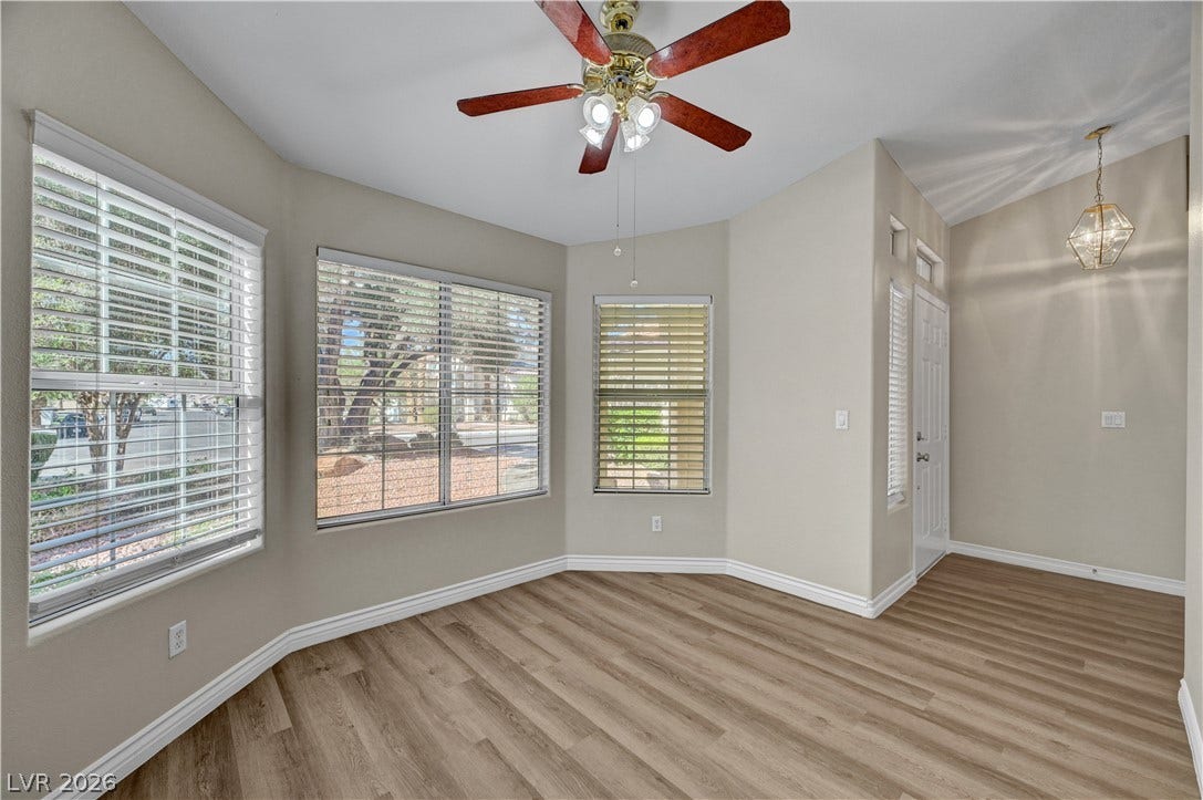 Warm wood-look flooring and multiple windows frame a welcoming entrance area.