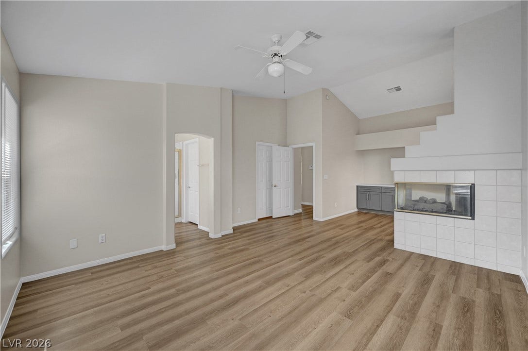 Vaulted ceilings and a tiled three-sided fireplace define this inviting open living space.
