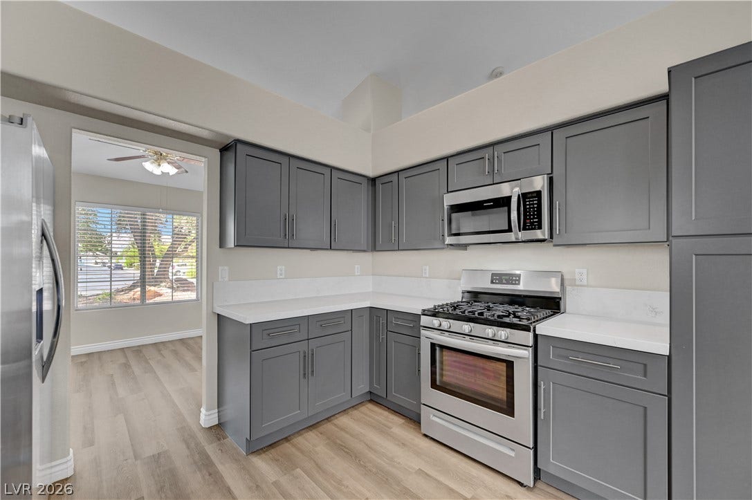 Streamlined cabinetry and modern solid-surface countertops anchor this thoughtfully designed kitchen layout.