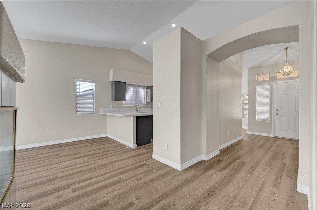 Smooth wood-look flooring and clean drywall arches connect the main living spaces.
