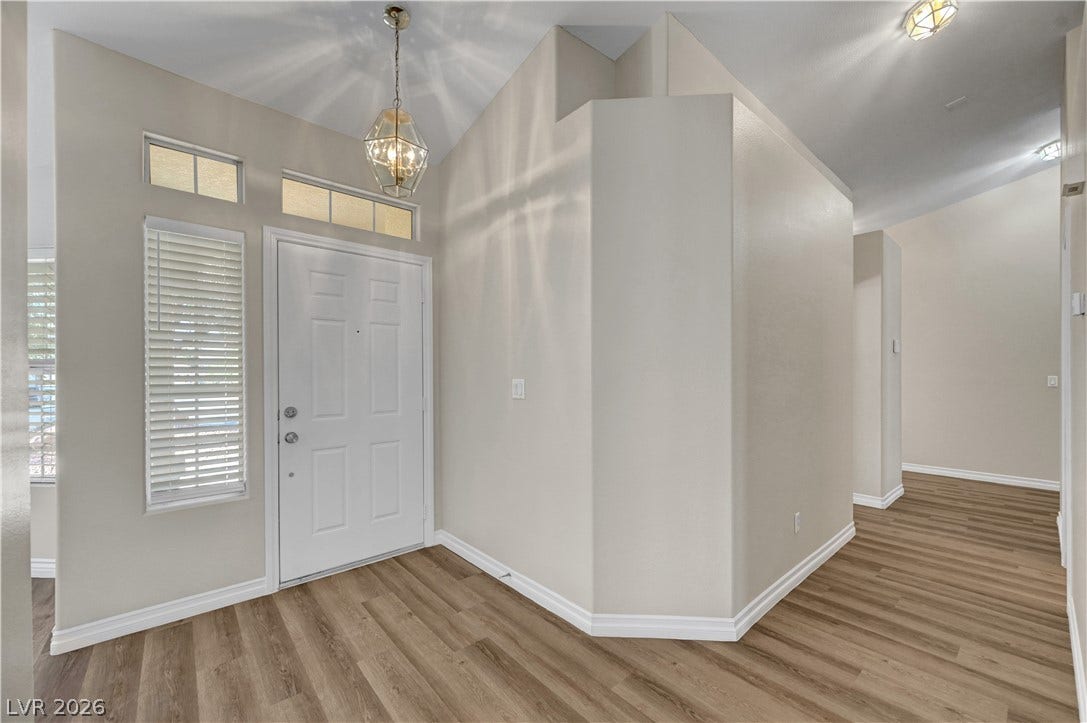 Gleaming wood-look floors complement the high vaulted ceilings of this welcoming entrance foyer.