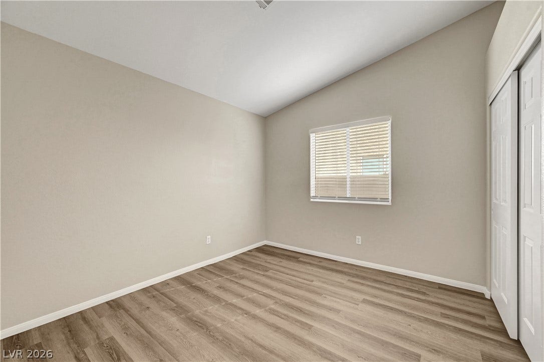 Sloped ceilings rise above durable plank flooring and a classic sliding closet door design.