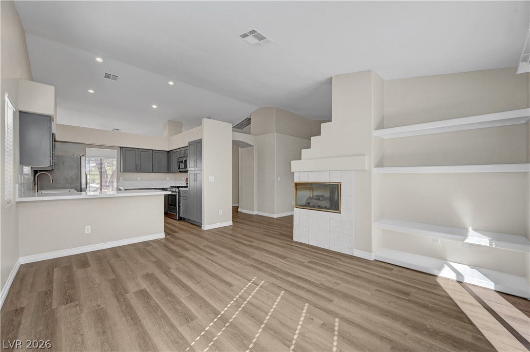 Gleaming wood floors anchor a spacious living area complete with built-in shelving and fireplace.
