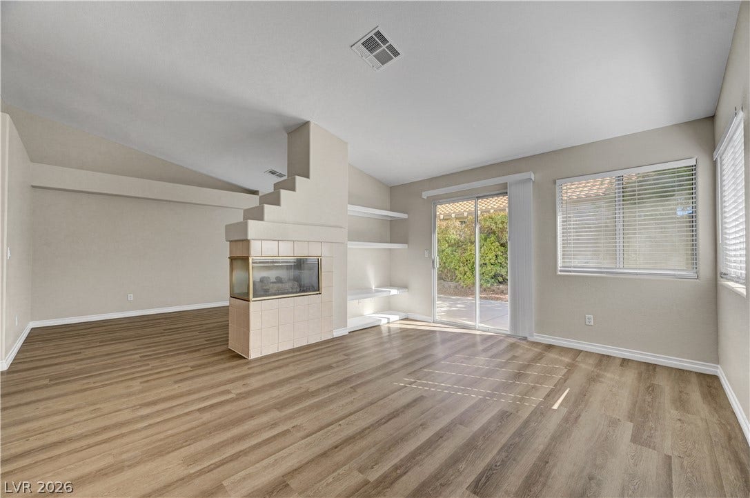 Sliding glass doors open to the patio from this living space with a central fireplace.