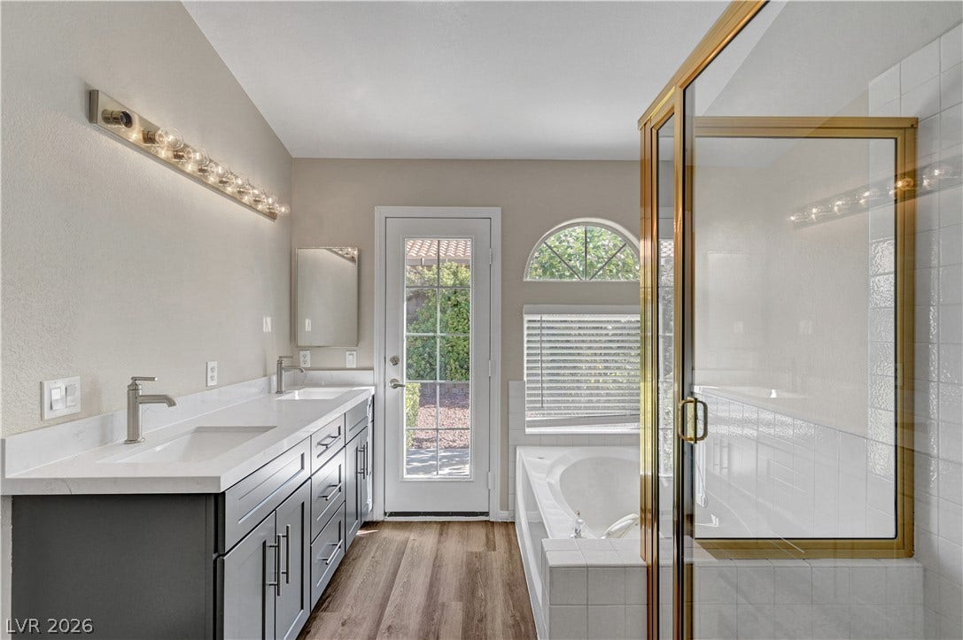 An inviting bathroom displays a modern double vanity alongside a deep soaking tub.