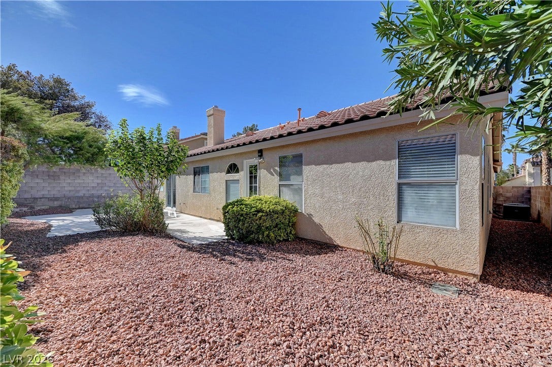 Stucco exterior walls and a classic tile roof define this low-maintenance backyard retreat.
