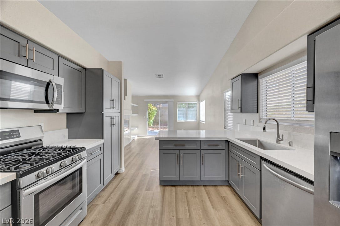 Modern cabinetry and solid countertops anchor this kitchen flowing seamlessly into the main living areas.