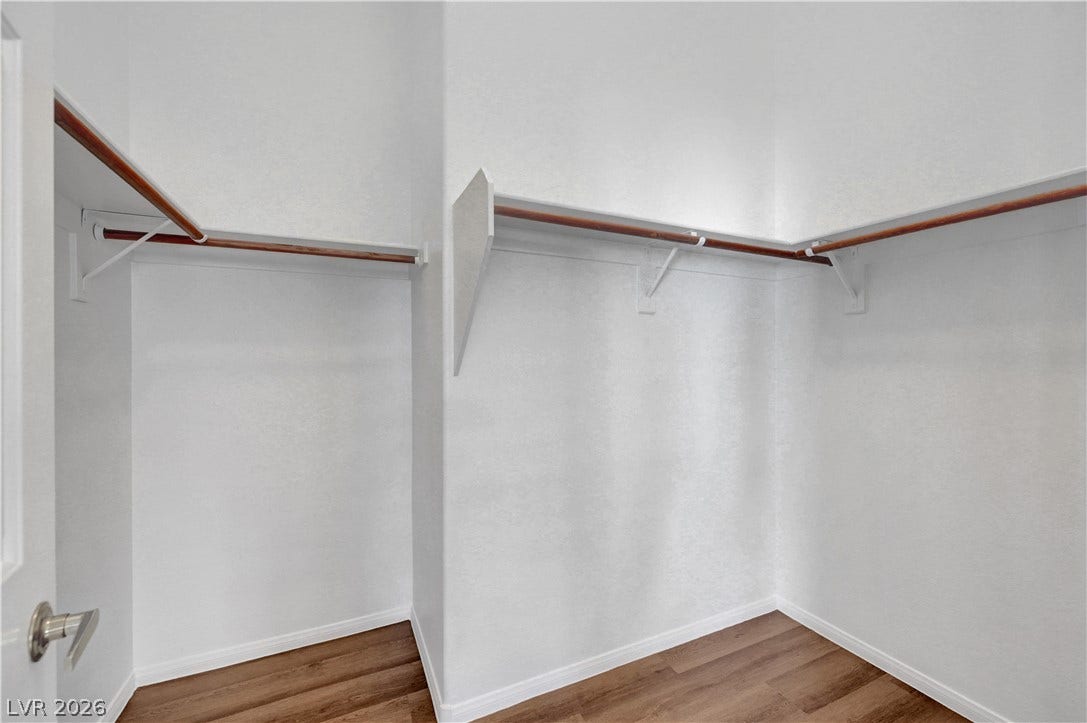 Hardwood floors complement the built-in shelving of this walk-in closet.