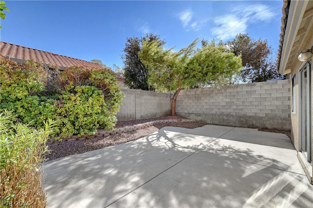 Concrete patio area enclosed by block fencing offers private outdoor space.