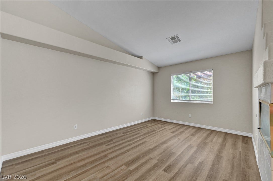 Angled ceilings and durable wood-look flooring enhance this versatile living space.