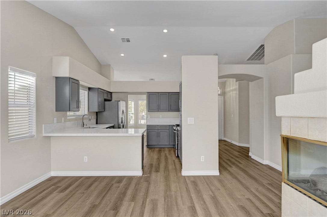 Plank flooring and an open layout connect the kitchen seamlessly to the main living area.
