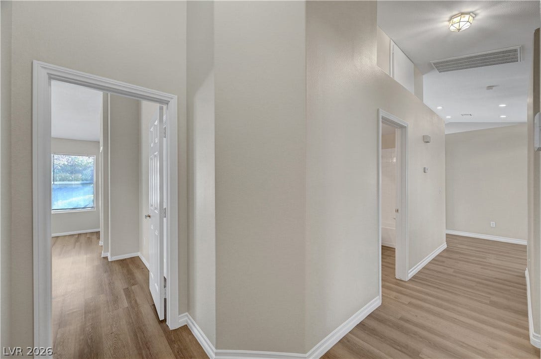 Clean lines and warm wood floors define this bright, multi-level hallway entry.