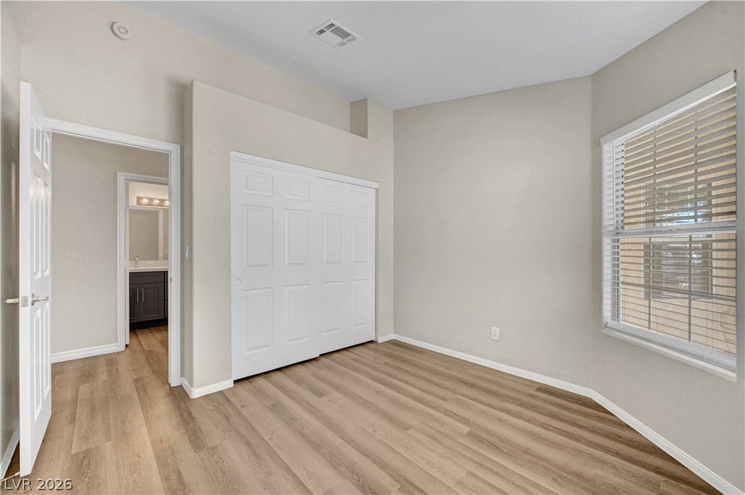 Smooth wood floors and tall ceilings anchor this quiet bedroom space.