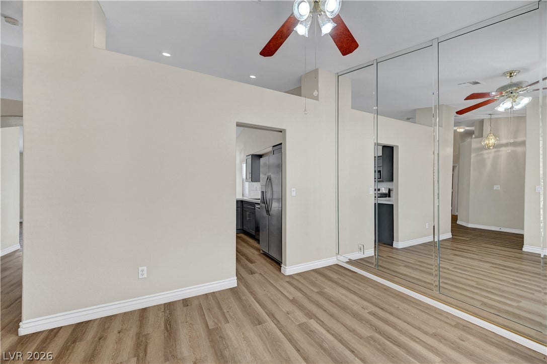 Mirrored sliding doors and warm wood-look flooring enhance this versatile interior space.