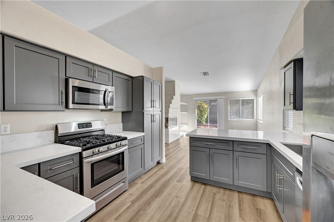 Sleek cabinetry and stone countertops anchor this modern, open-concept kitchen.