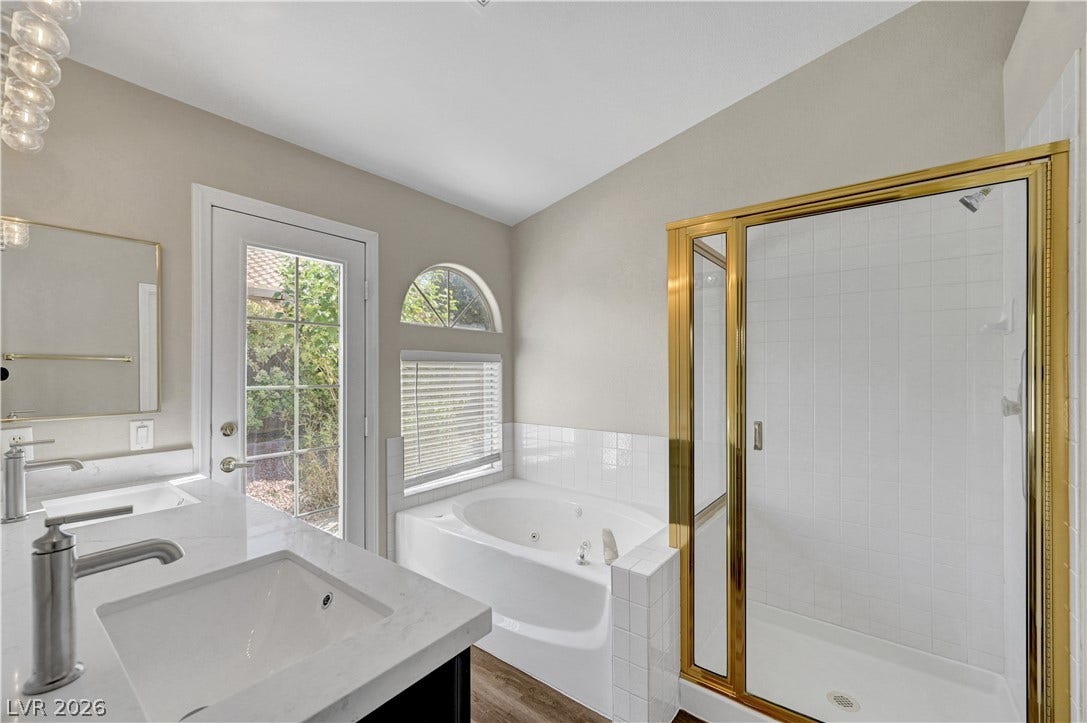 Double vanities, a glass-enclosed shower, and a soaking tub define this bathroom retreat.