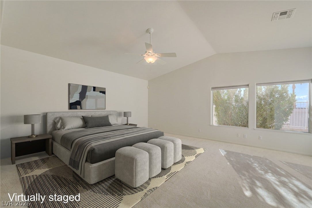 1112 Boletus Drive, Henderson, NV 89011 Plentiful natural light streams through wide windows onto the carpeted floors of this bedroom.