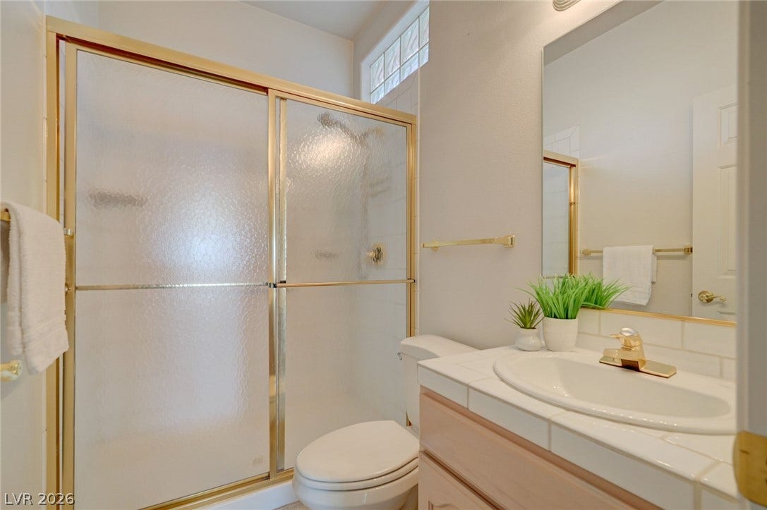 1112 Boletus Drive, Henderson, NV 89011 Tiled countertops and a glass-enclosed shower stall define this classic bathroom space.