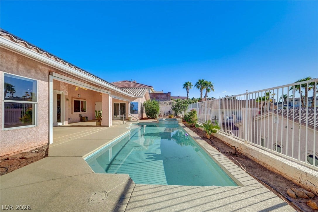 1112 Boletus Drive, Henderson, NV 89011 An inviting swimming pool sparkles alongside a covered concrete patio and protective iron fencing.