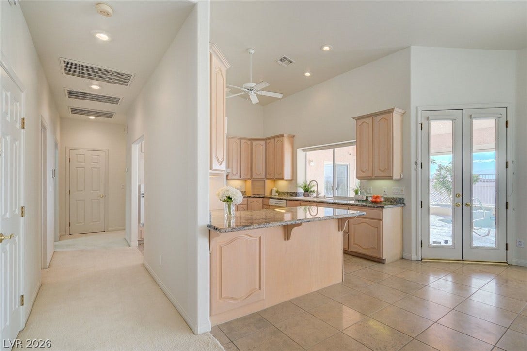 1112 Boletus Drive, Henderson, NV 89011 Granite countertops and recessed lighting elevate this open kitchen layout with seamless patio access.