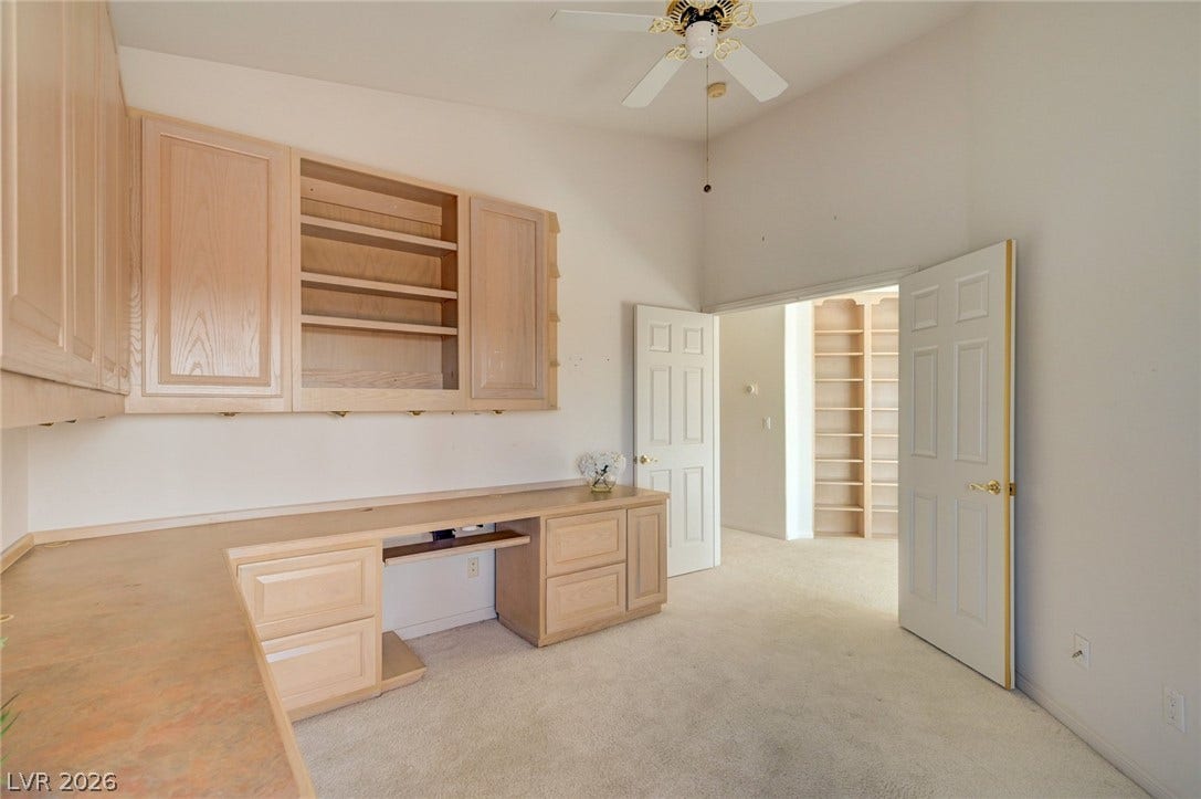 1112 Boletus Drive, Henderson, NV 89011 A quiet home workspace features built-in cabinetry, an integrated desk, and soft carpeted flooring.