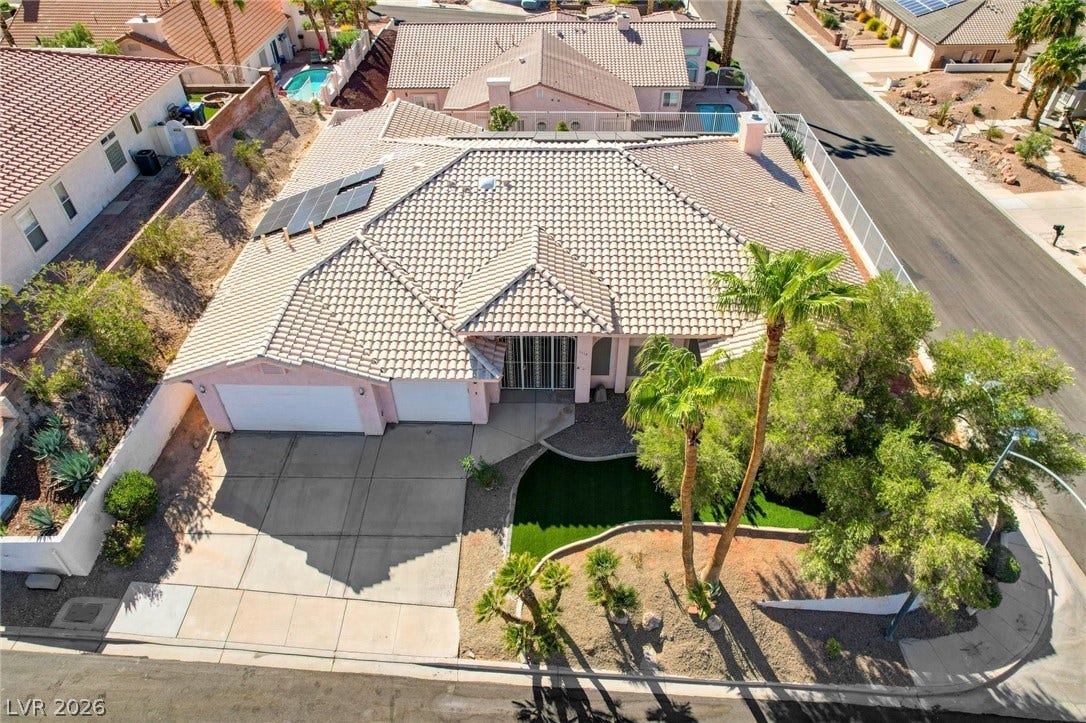 1112 Boletus Drive, Henderson, NV 89011 An aerial perspective showcases a tile roof home featuring integrated solar panels and desert landscaping.