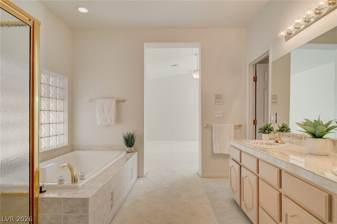 1112 Boletus Drive, Henderson, NV 89011 An inviting bathroom features a deep soaking tub alongside a spacious tile vanity.