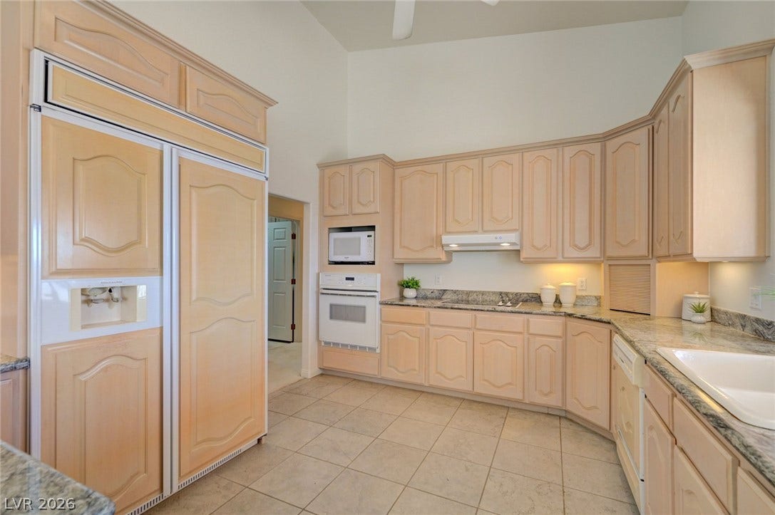 1112 Boletus Drive, Henderson, NV 89011 A spacious kitchen features extensive wood cabinetry and expansive granite countertops over tile flooring.