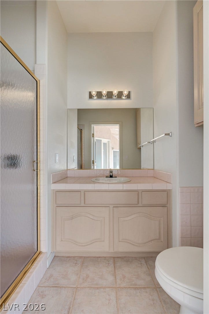 1112 Boletus Drive, Henderson, NV 89011 High ceilings and neutral tile flooring define this classic bathroom vanity area.