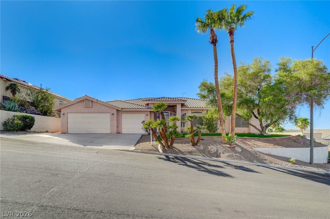 1112 Boletus Drive, Henderson, NV 89011 Palm trees accent the classic stucco facade and tiled roofline of this multi-car garage home.