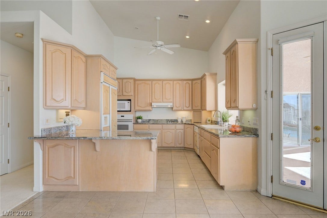 1112 Boletus Drive, Henderson, NV 89011 High vaulted ceilings and ample cabinetry define this spacious, tiled culinary workspace.