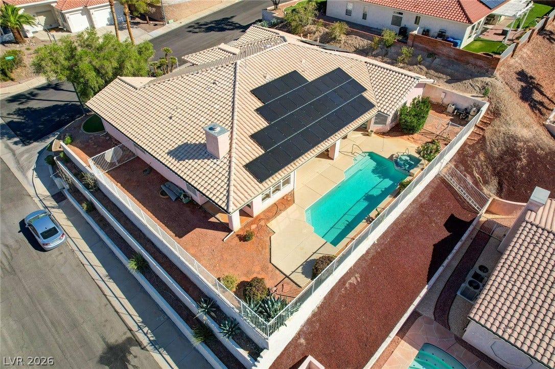 1112 Boletus Drive, Henderson, NV 89011 An aerial perspective showcases a tiled roof with integrated solar panels above a sparkling pool.