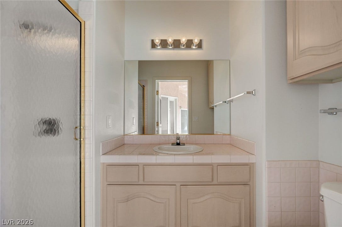 1112 Boletus Drive, Henderson, NV 89011 Tiled countertops and classic wood cabinetry define this functional vanity area.