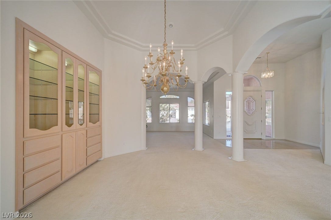 1112 Boletus Drive, Henderson, NV 89011 A classic chandelier hangs above carpeted flooring and custom built-in cabinetry in this formal space.