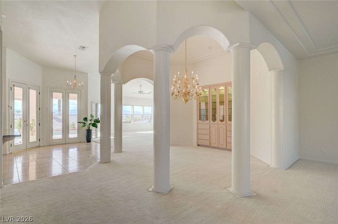 1112 Boletus Drive, Henderson, NV 89011 Soaring ceilings, elegant architectural columns, and glass-paneled doors define this open, light-filled interior entryway.