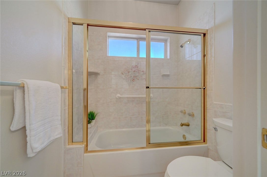 1112 Boletus Drive, Henderson, NV 89011 A glass-enclosed shower and tub combination anchors this functional bathroom space.