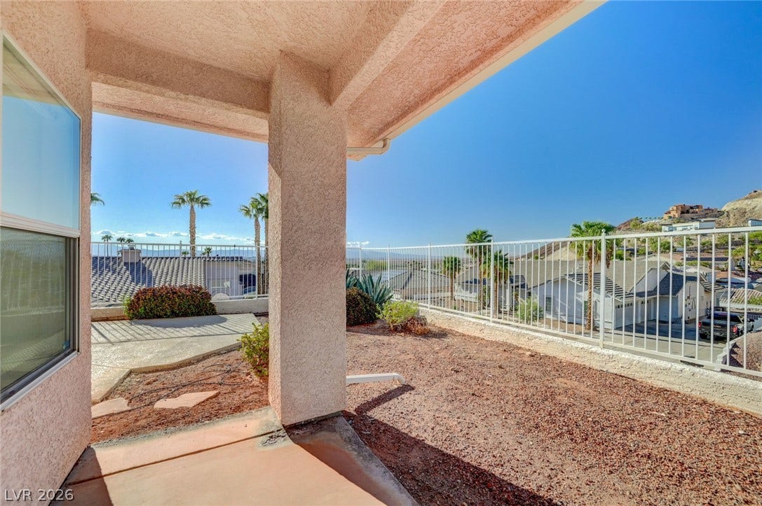 1112 Boletus Drive, Henderson, NV 89011 A covered patio overlooks a sunny backyard enclosed by protective metal fencing.