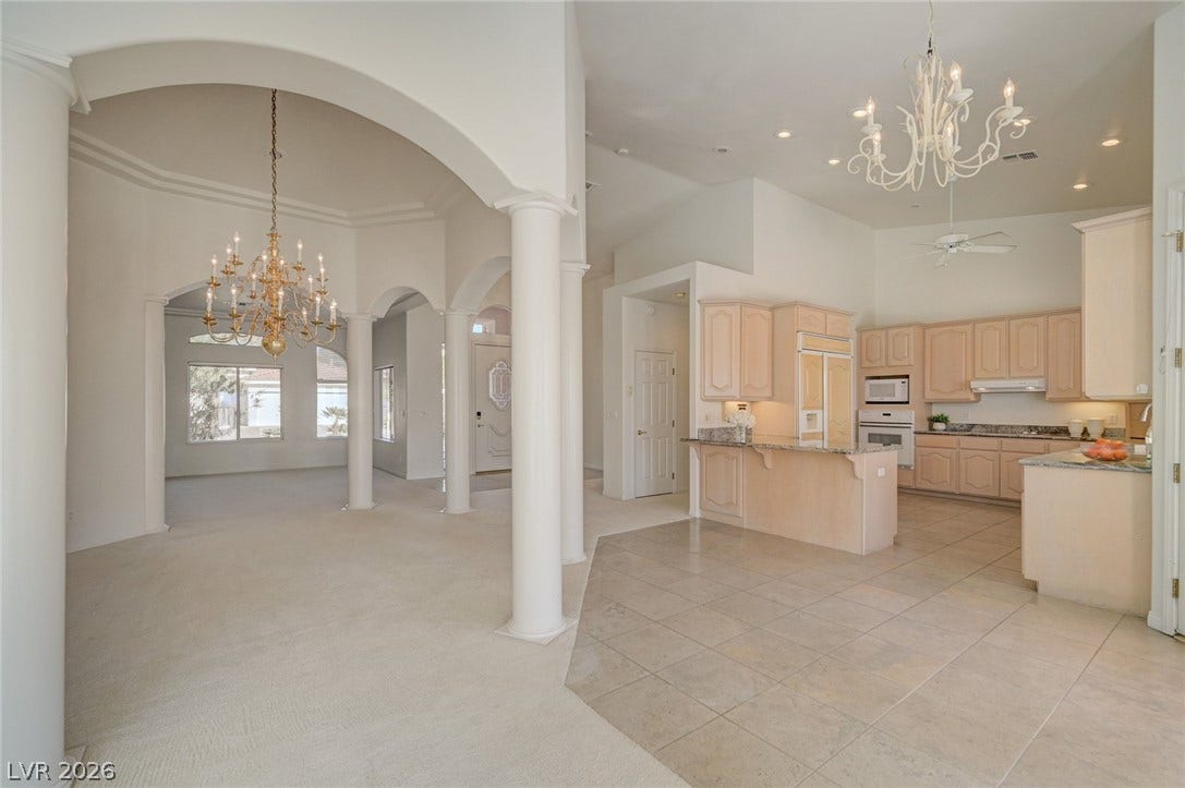 1112 Boletus Drive, Henderson, NV 89011 Classical columns and elegant arches frame the transition from the tiled kitchen to carpeted living spaces.