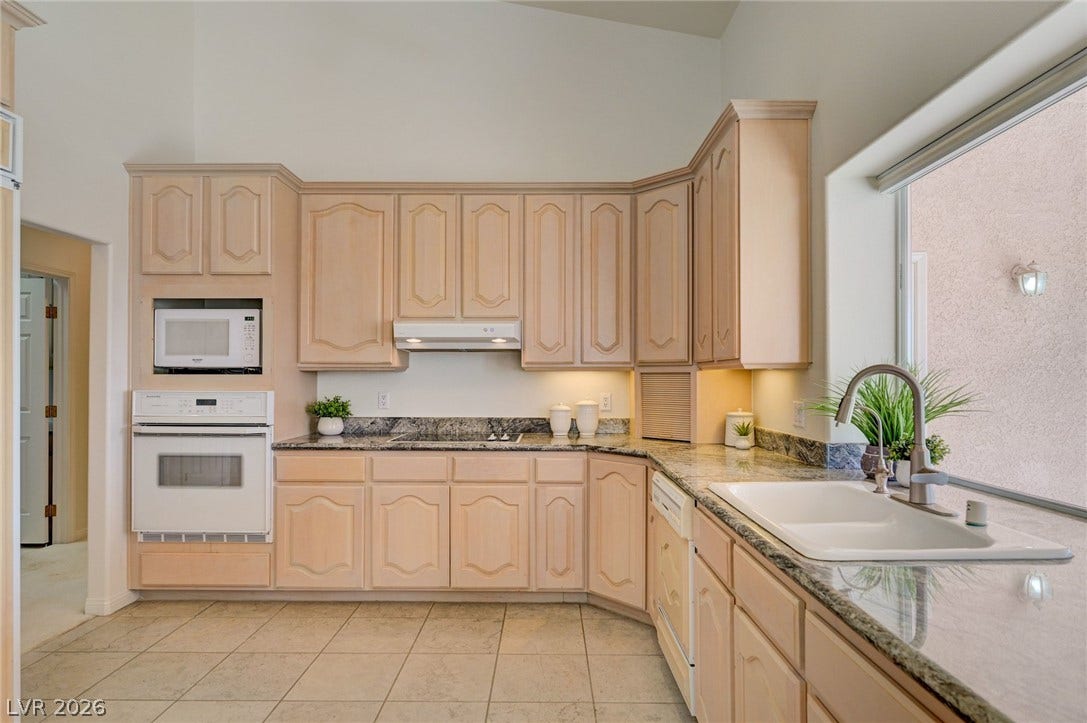 1112 Boletus Drive, Henderson, NV 89011 High ceilings and extensive stone countertops define this well-appointed kitchen space.