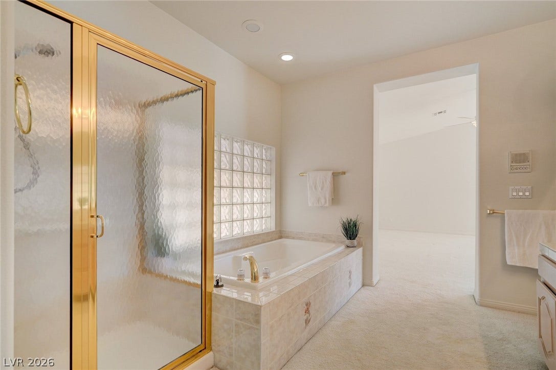 1112 Boletus Drive, Henderson, NV 89011 A spacious bathroom features a glass block window accenting the large tile-surrounded soaking tub.